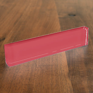 Rote, rosa und orangefarbene Kleidung hängen neben Namensplakette