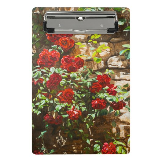 Rote Rosen gegen eine Steinmauer Mini Klemmbrett (Vorderseite)
