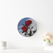 Rote Rosen gegen einen hellen blauen Himmel Runde Wanduhr (Zuhause)
