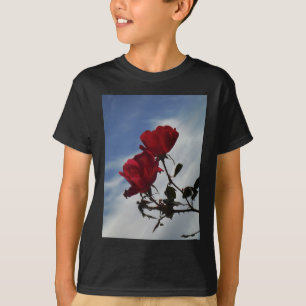 Rote Rosen gegen einen hellen blauen Himmel T-Shirt