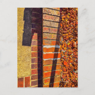 Rote Ziegelmauer mit dramatischem Sonnenlicht und Postkarte
