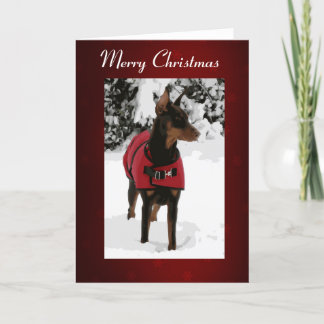Roter Dobermann in der Schnee-Weihnachtskarte Feiertagskarte