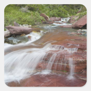Roter Felsen in Baring Creek im Glacier National Quadratischer Aufkleber