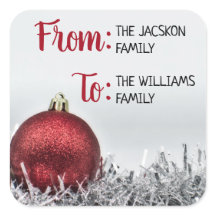 Roter glitzernder Weihnachtsball mit Silbergarland