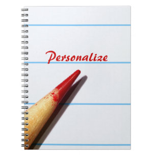 Roter Lehrer-Bleistift auf gezeichnetem Papier mit Notizblock