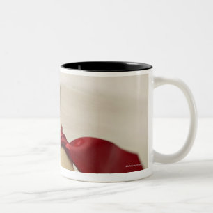 Rotes Band gebunden, um Leckerei zu verfolgen Zweifarbige Tasse