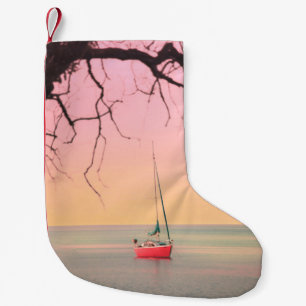 ROTES BOOT AM STRAND WÄHREND DER SONNE KLEINER WEIHNACHTSSTRUMPF