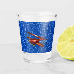 Rotes Doppeldeckerflugzeug auf blauem Kreis- und S Schnapsglas