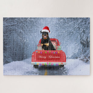 Rottweiler-Hund im Schnee sitzt im Weihnachts-LKW Puzzle
