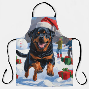 Rottweiler läuft im Schnee mit Weihnachtshut Schürze