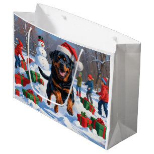 Rottweiler läuft im Schnee mit Weihnachtsmütze Große Geschenktüte