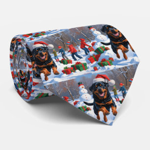 Rottweiler läuft im Schnee mit Weihnachtsmütze Krawatte