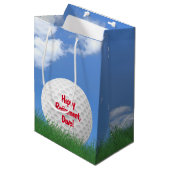 Ruhegolfball im Gras mit Namen Mittlere Geschenktüte (Vorderseite Schrägansicht)