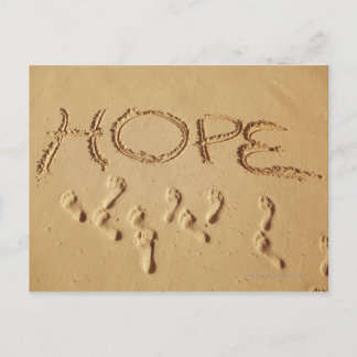 Sand schreibt "Hope" am Strand mit dem Postkarte