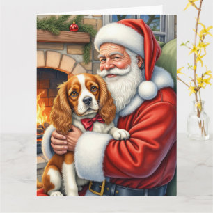 Santa Claus hält einen Cavalier King Charles Spani Karte