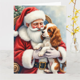 Santa Claus hält einen Cavalier King Charles Spani Karte