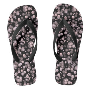 Scatterings von rosa und weißen Perlen auf schwarz Badesandalen
