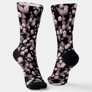 Scatterings von rosa und weißen Perlen auf schwarz Socken