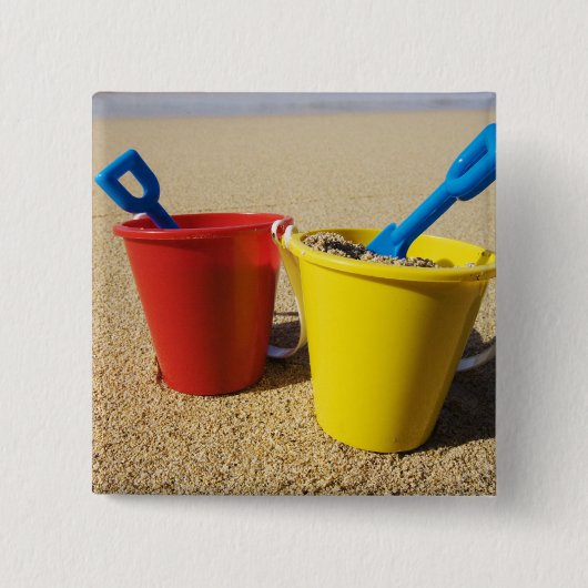 Schaufeln und Eimer auf Sandy-Strand Button (Vorderseite)