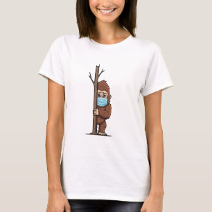 Scheuer Bigfoot in medizinischer Maske schaut hint T-Shirt