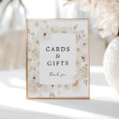 Schild mit weißen Blumenkarten und Geschenken