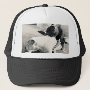 Schlafender Pitbull-Welpe und Babys kuscheln Truckerkappe