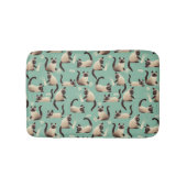 Schlechte siamesische Katzen klopfen über Badematte (Vorderseite)