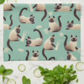 Schlechte siamesische Katzen klopfen über Geschirrtuch (Gefaltet)