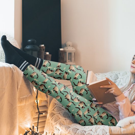 Schlechte siamesische Katzen klopfen über Leggings