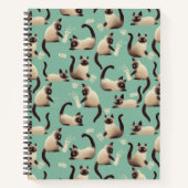 Schlechte siamesische Katzen klopfen über Notizblock (Vorderseite)