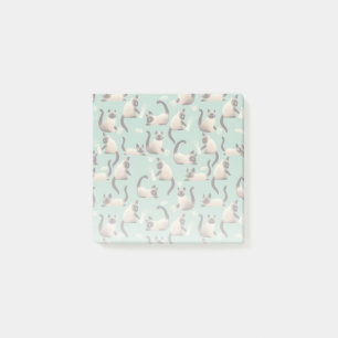 Schlechte siamesische Katzen klopfen über Post-it Klebezettel