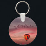 Schlüsselanhänger mit Heißluftballon in Flankenfar<br><div class="desc">Farbenfroher Heißluftballon,  der zwischen bunten Wolken fliegt,  für Abenteuer- und Risikoliebhaber. Ideal für Freunde,  Familie und Kollegen,  klicken Sie bitte auf den Personalize-Button,  um ihn mit Ihrem Text oder Namen anzupassen.</div>