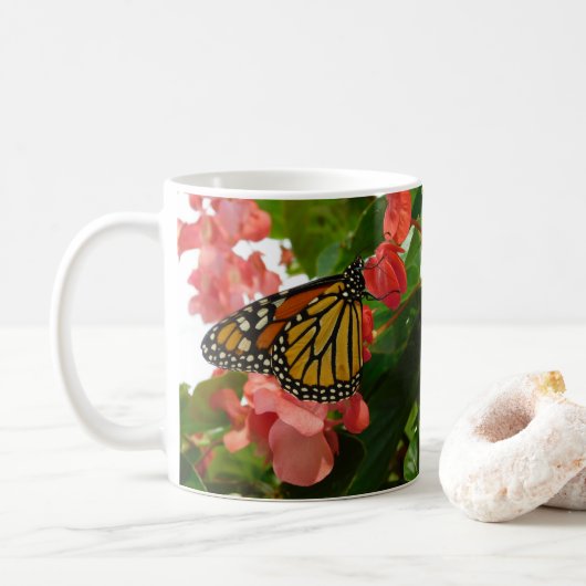 Schmetterling auf der Tasse der roten Blume (Mit Donut)