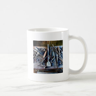 Schmiedewerkzeuge auf dem Tisch Kaffeetasse