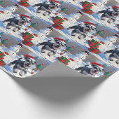 Schnauzer läuft im Schnee mit Weihnachtshut Geschenkpapier (Ecke)