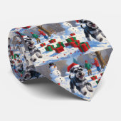 Schnauzer läuft im Schnee mit Weihnachtshut Krawatte (Gerollt)