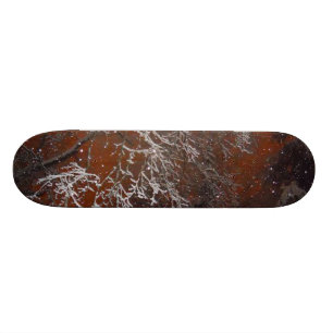 Schnee umfaßte Baumaste gegen Red Storm-Himmel Skateboard
