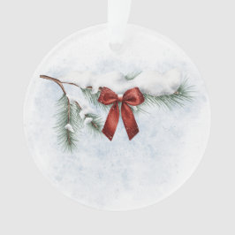 schneebedeckter Kiefernzweig mit festlichem rotem  Ornament