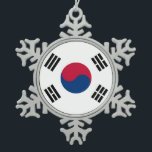 Schneeflocke mit Südkoreaflagge Schneeflocken Zinn-Ornament<br><div class="desc">Fügen Sie Ihrem Urlaubsstil eine Touch internationalen Flairs hinzu mit unserem eleganten Weihnachtsschneeflocken unter der Flagge Südkoreas. Dieses einzigartige und wunderschön gestaltete Ornament verbindet den festlichen Charme einer Schneeflocke mit den lebhaften Farben der südkoreanischen Flagge und macht es zu einer perfekten Ergänzung zu Ihrem Weihnachtsbaum oder Ihrer Feiertagsausstellung. Jedes Dekor...</div>