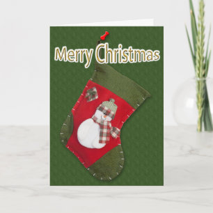 Schneemann auf Weihnachtsstrumpf über Grün Feiertagskarte