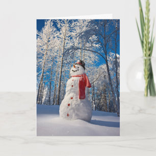 Schneemann vor dem schneebedeckten Wald Feiertagskarte
