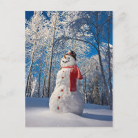 Schneemann vor dem schneebedeckten Wald