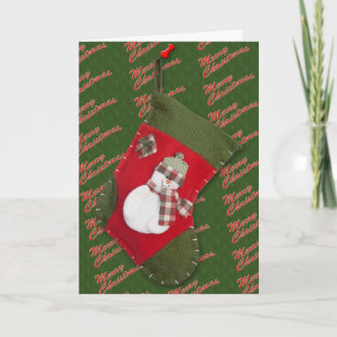 Schneemann-Weihnachtsstrumpf über grünem Hintergru Feiertagskarte