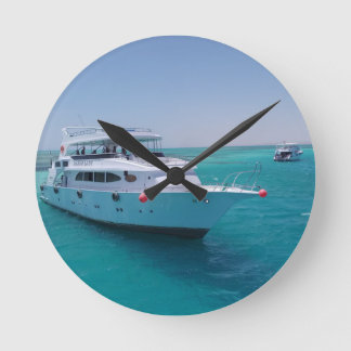 Schneeweiße Yacht in der Nähe der weißen Insel im  Runde Wanduhr