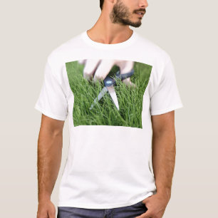 Schnitt des Grases mit einem Paar Scheren T-Shirt