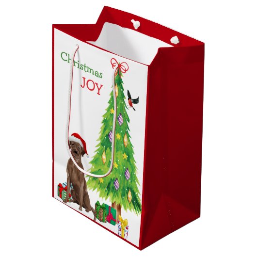 Schokolade Labrador Weihnachtsmannmütze Welpe und Mittlere Geschenktüte (Vorderseite Schrägansicht)