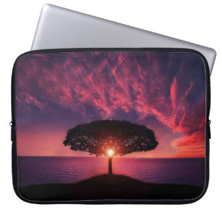 Schöne Landschaft mit der Sonne, die hinter ein Laptopschutzhülle