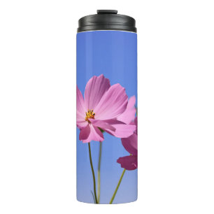 schöne rosa Blume, die einen klaren, blauen Himmel Thermosbecher