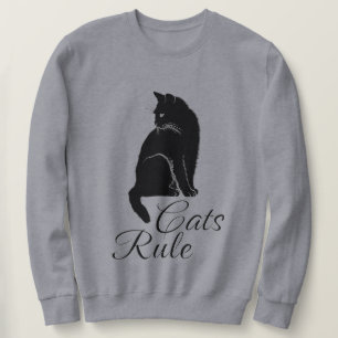 Schöne schwarze sitzende Katze mit "Katzen regiere Sweatshirt