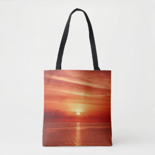 Schöner farbenfroher Sonnenaufgang am Meer mit Dra Tasche